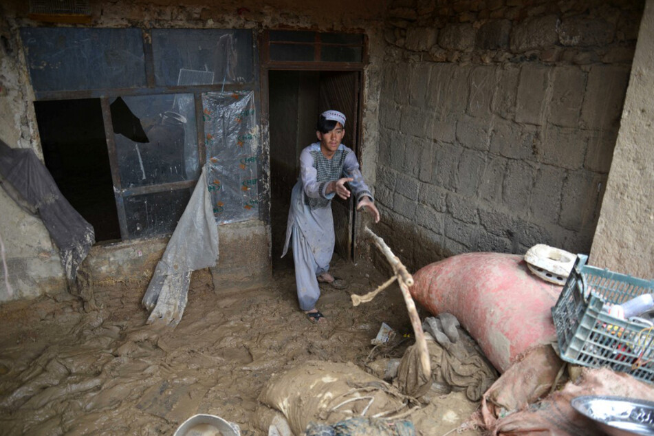 Ein afghanischer Mann entfernt nach schweren Sturzfluten Trümmer aus seinem Haus.