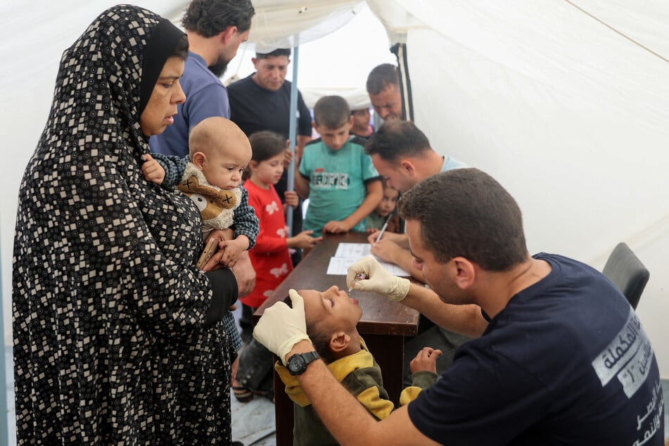 A medic administers a polio vaccine to a Palestinian child at Abdel Aziz Rantissi hospital in Gaza City's Nasr district which was reopened on Saturday after sustaining heavy damage in Israeli bombardment of the area.