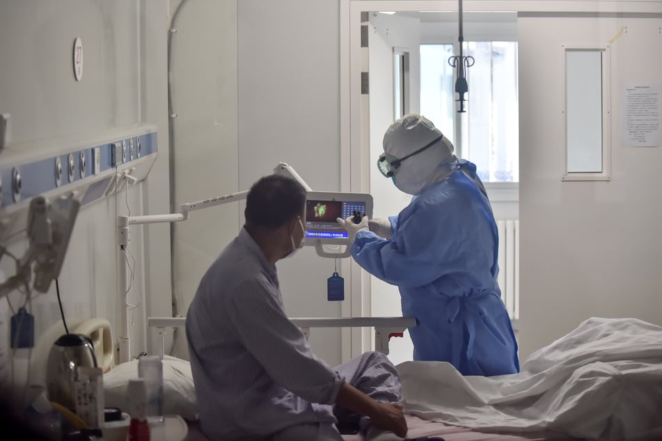 Eine Krankenschwester stellt für einen COVID-19-Patienten auf einer Isolierstation im Pekinger Ditan-Krankenhaus ein Fernsehgerät ein.