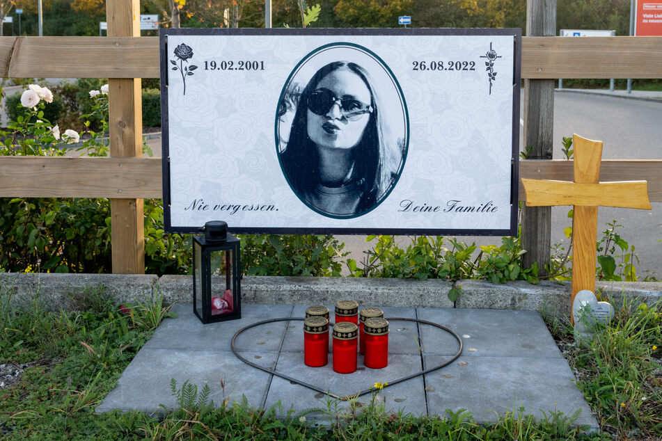 Am Rand des Parkplatzes eines Möbelhauses erinnern ein Plakat, ein Kreuz und Kerzen an die junge Frau, die bei der Raserfahrt ums Leben kam.