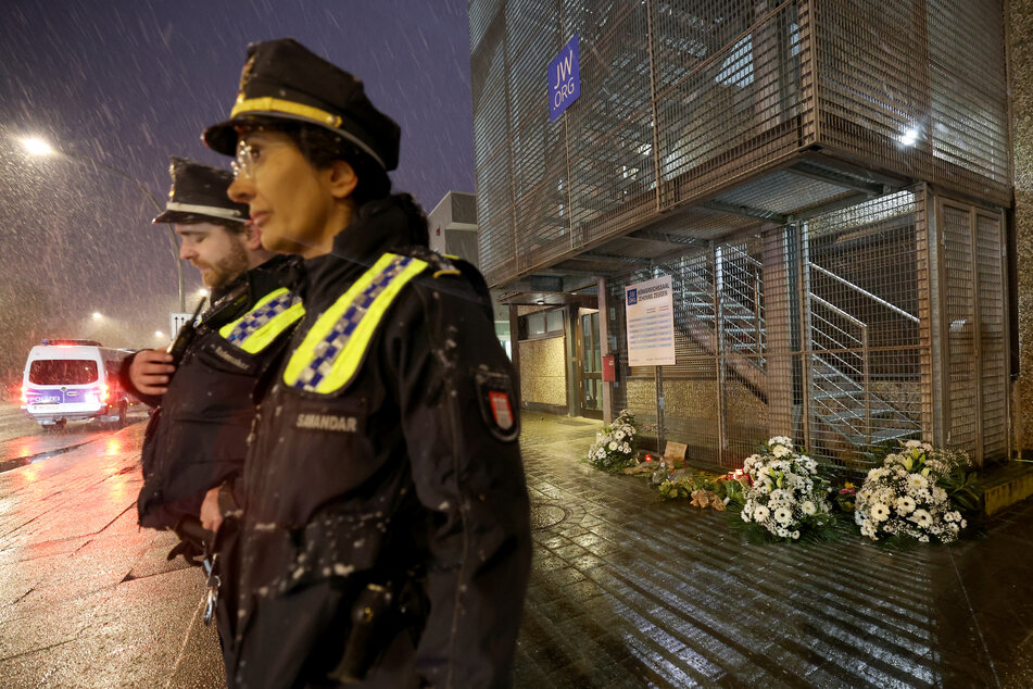 Polizeibeamte stehen nach der Tat vor dem Gebäude der Zeugen Jehovas im Stadtteil Alsterdorf.