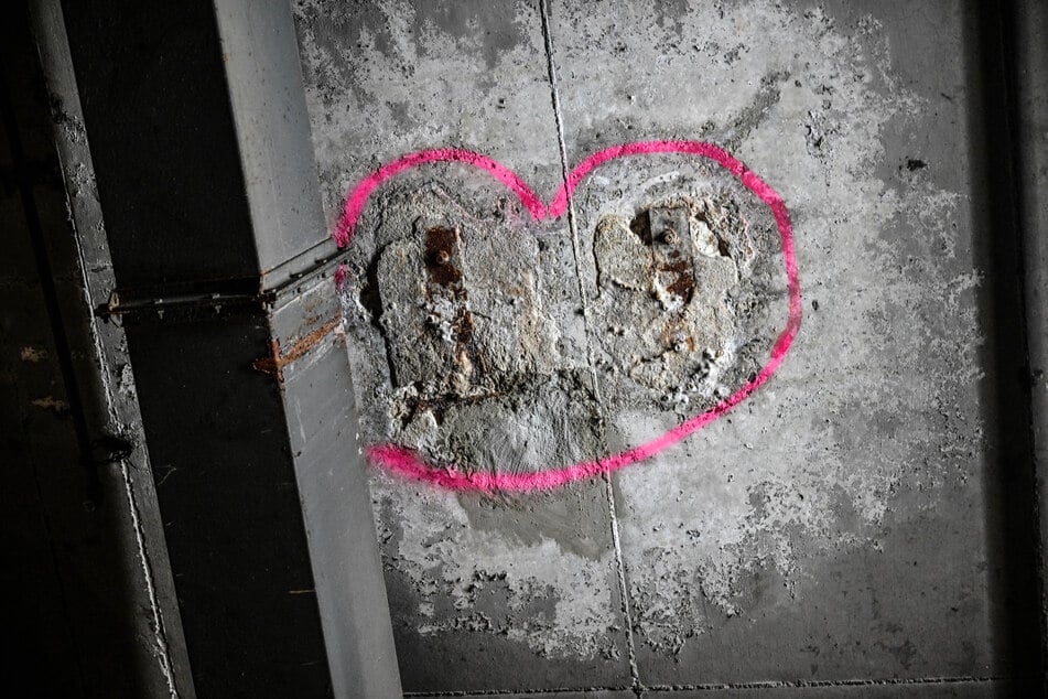 Überall in der Tiefgarage sind pinke Markierungen zu sehen, die offenbar offenen Bewehrungsstahl umkreisen.