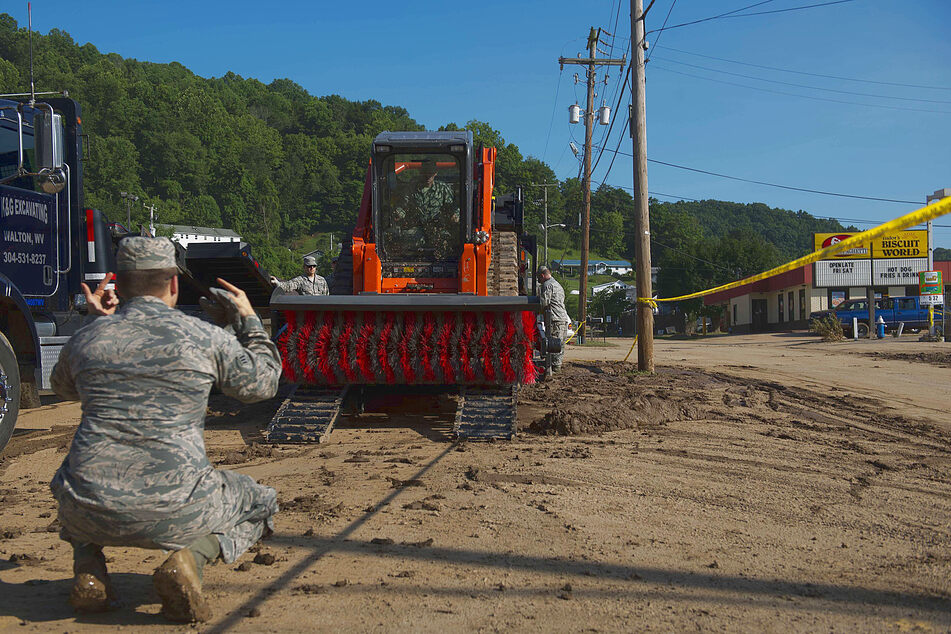 Members of the West Virginia Air National Guard unload a street sweeper on June 26, 2016 in Clendenin, West Virginia, after a devastating once in 1000 year flood event. Climate change is making such events more likely and more intense.