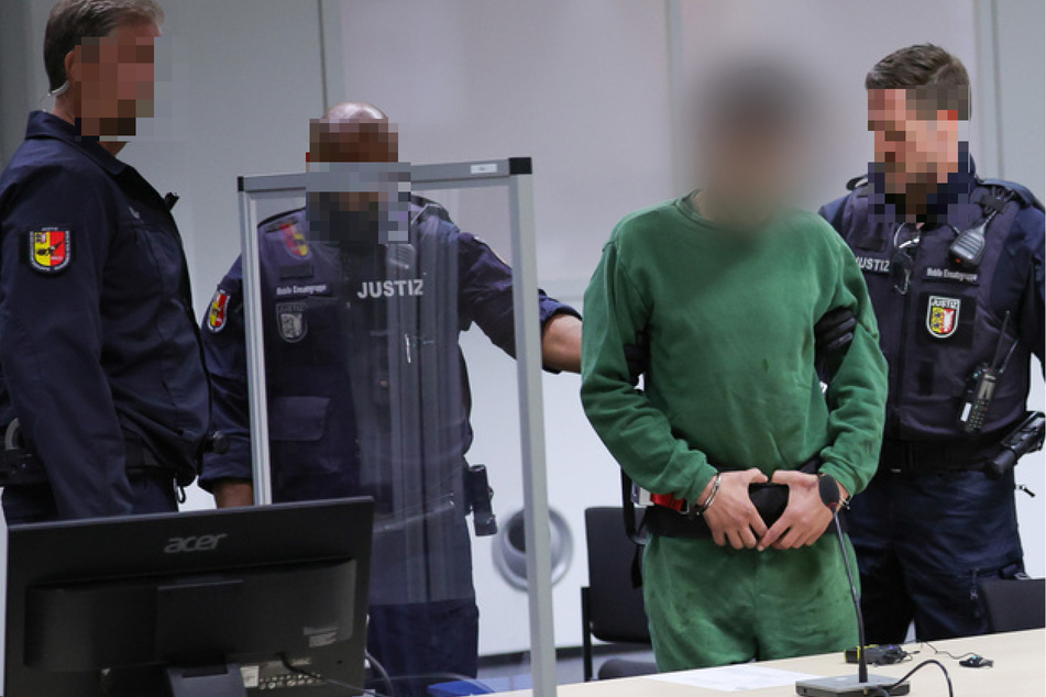 Der Angeklagte Ibrahim A. (34, 3. v. l.) wird in den Gerichtssaal im China Logistic Center gebracht.