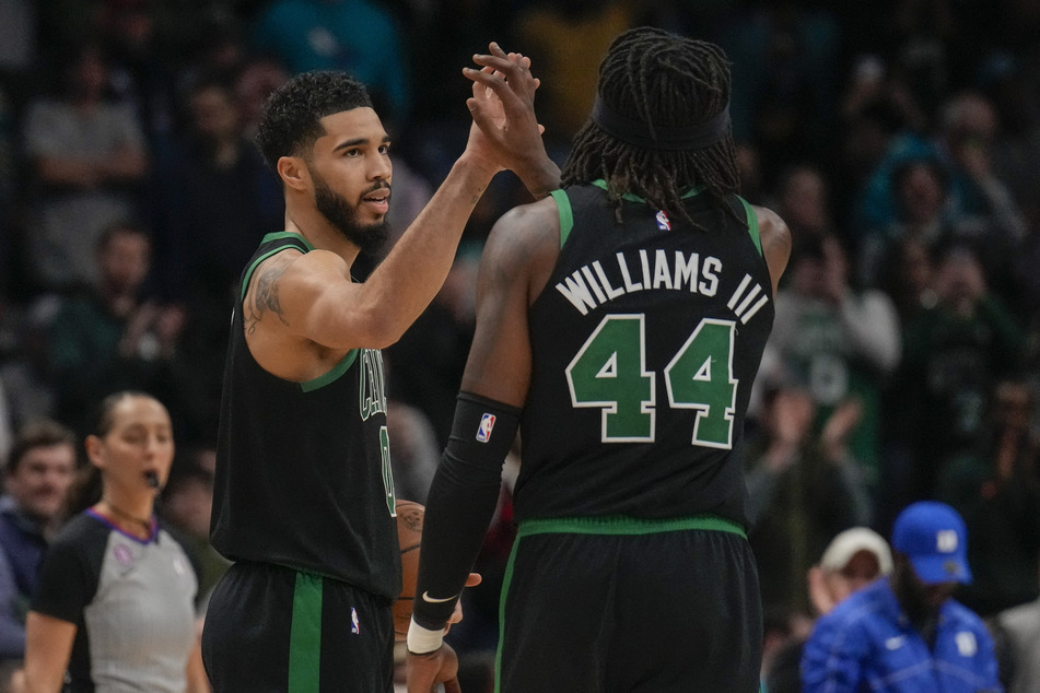Jayson Tatum (l.) scored a season-high 51 points to propel the Boston Celtics to a win against the Charlotte Hornets.