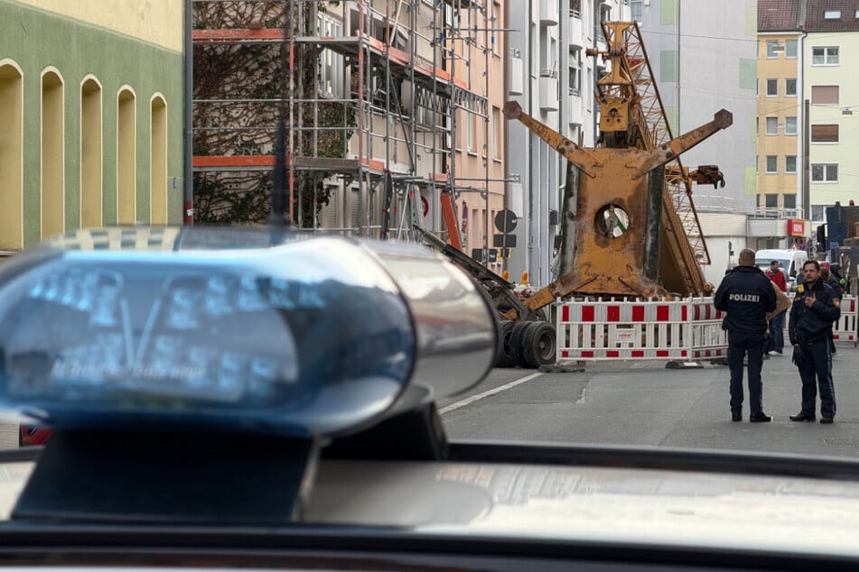 Polizisten stehen an der abgesperrten Martin-Richter-Straße, wo ein Kran beim Aufbau umgekippt ist.