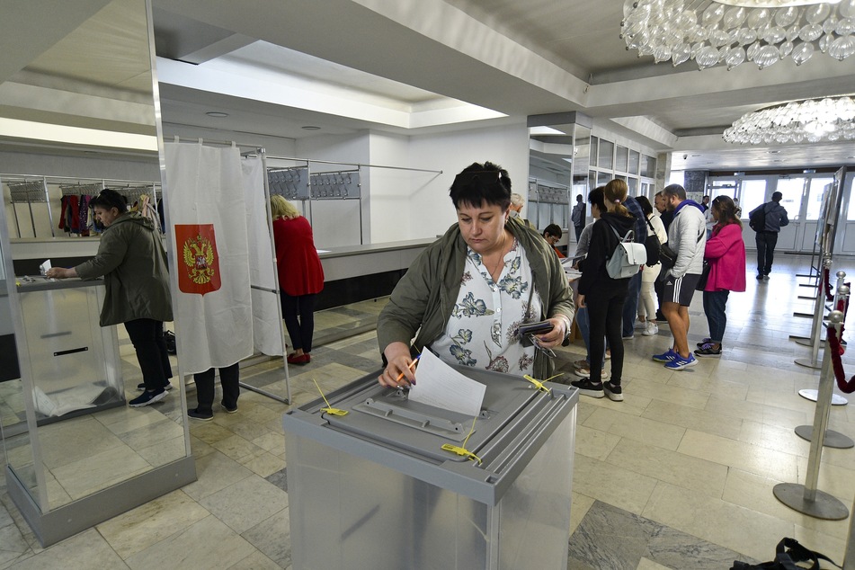 Menschen aus den von Russland unterstützten und von Separatisten kontrollierten Regionen Luhansk und Donezk, die auf der Krim leben, stimmen während des Scheinreferendums ab.