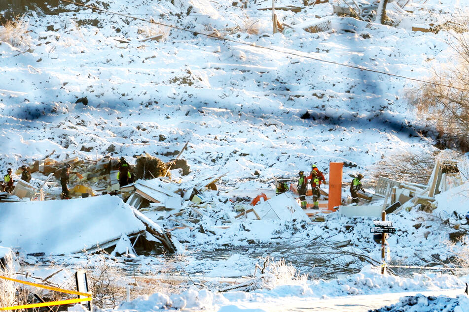 Rettungsmannschaften sind nach einem Erdrutsch bei zerstörten Gebäuden im Einsatz.