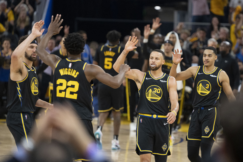Curry (2nd from r.) celebrates with his Warriors teammates during the second quarter.