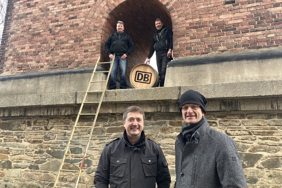 Die Whisky-Profis aus Dresden (oben) sowie Markus Fischer von der DB Netz AG und Bürgermeister Mike Purfürst (unten, v.l.) freuen sich über den neuen Brücken-Schnaps.