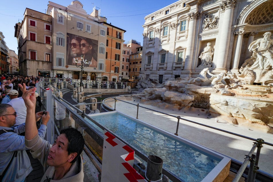 Trotz Restaurierungsarbeiten lockt der Brunnen unzählige Touristen an.