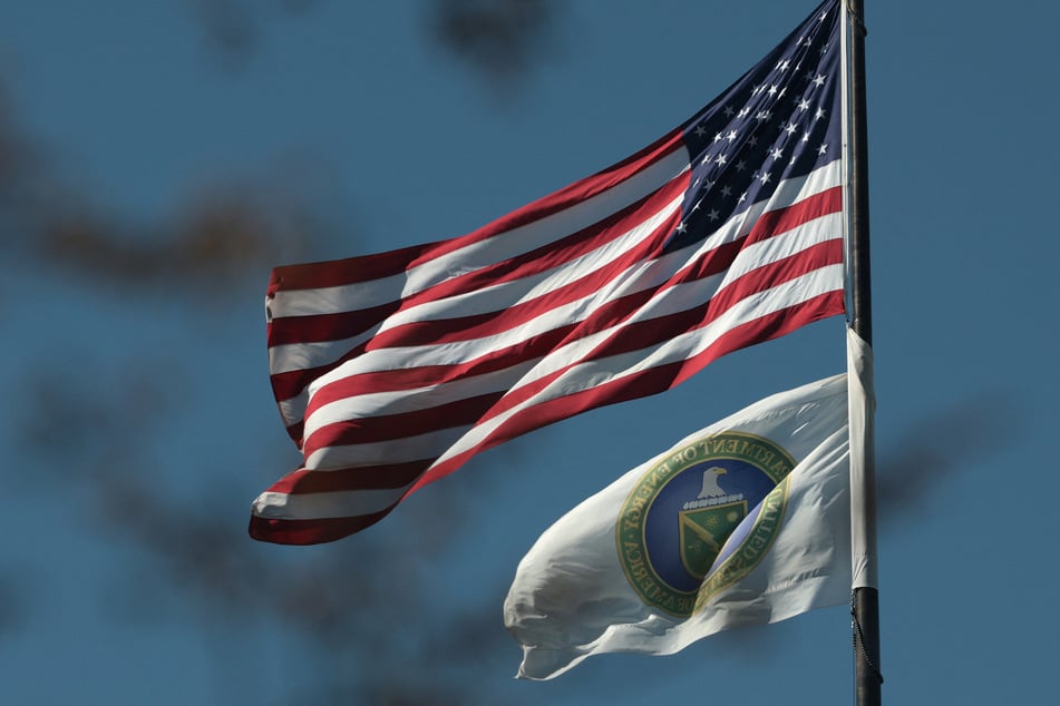 A US flag and the flag of the Department of Energy fly outside the headquarters in Washington DC.