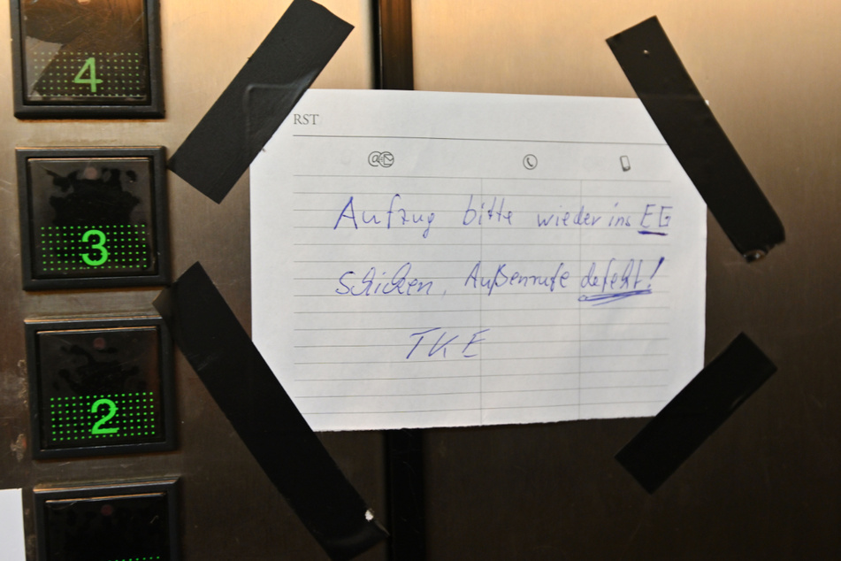 Ein Zettel bittet darum, den teildefekten Fahrstuhl stets wieder ins Erdgeschoss zu schicken.