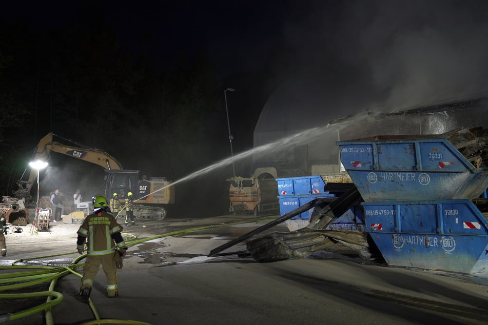 Einsatzkräfte der Feuerwehr löschen einen Brand in einem Industriegebiet nördlich von München.