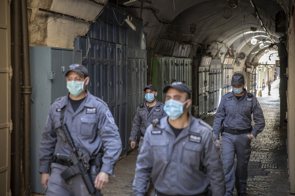 Israelische Polizisten mit Mundschutz patrouillieren in der Altstadt von Jerusalem.