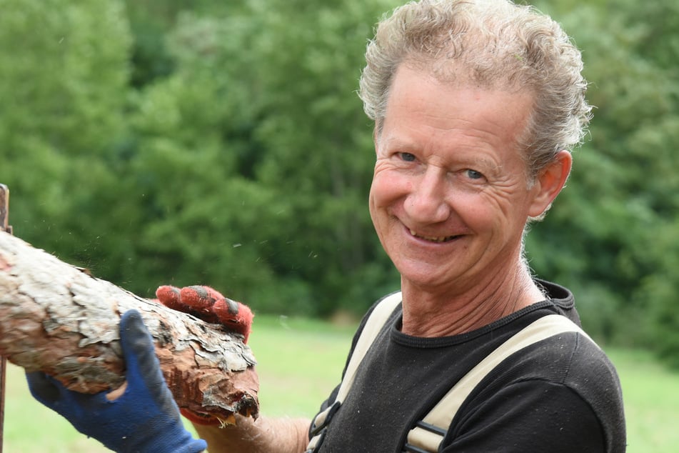 Storchenvater Jörg Spörl (62) stapelt in seinem Garten Feuerholz.
