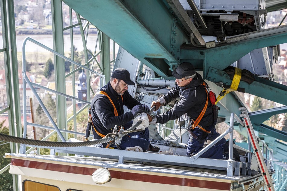 Hier lösen Mitarbeiter auf dem Dach des Wagens das Zugseil. Für Sicherheit sorgen zwei Fangbremsen und ein Sicherungsseil.