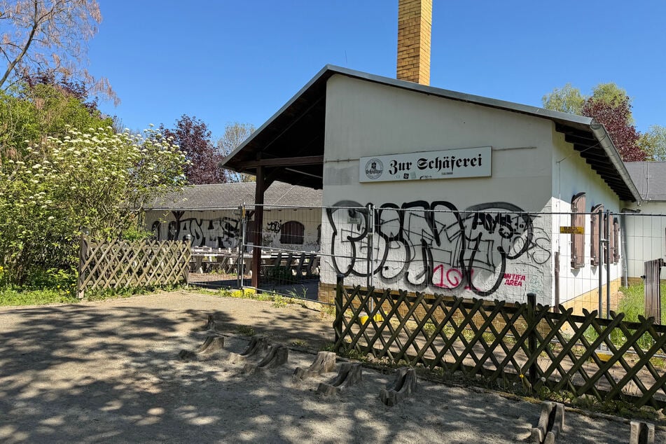 Graffiti und ein Bauzaun schmücken das Gebäude.