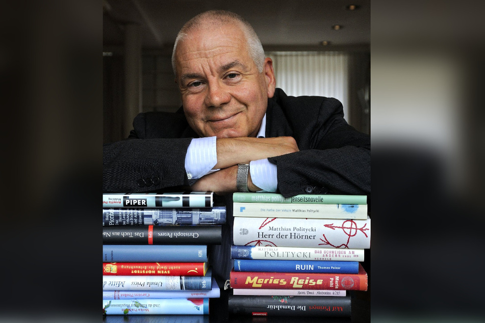 Der Schriftsteller Matthias Politycki (66) lehnt sich auf einen Stapel Bücher. Er lebt inzwischen in Wien.