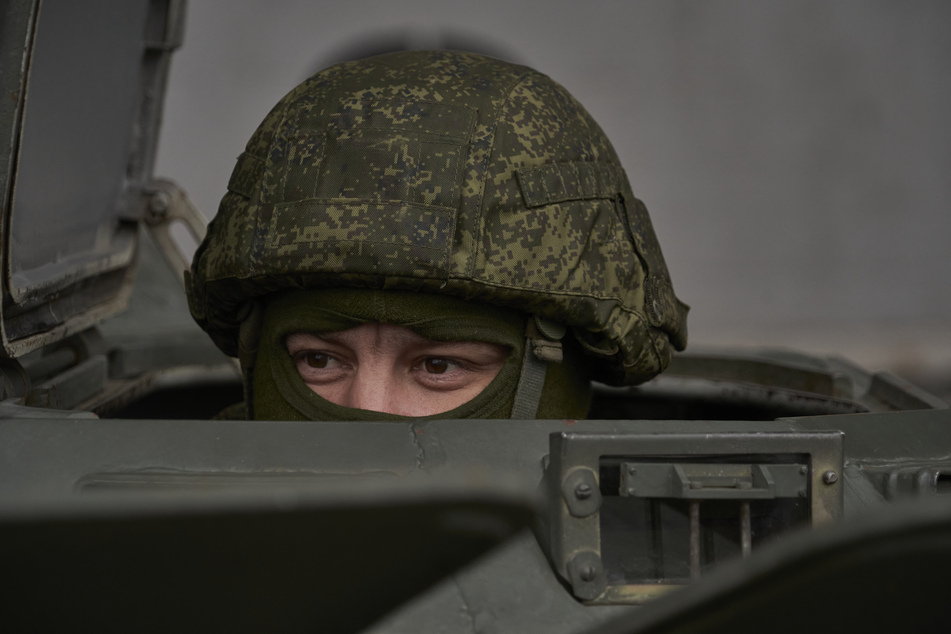 Ein russischer Soldat wacht aus der Luke eines Militärfahrzeugs.