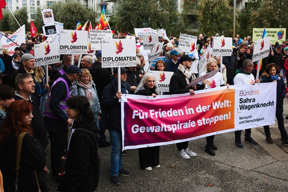 Unter die Demonstranten haben sich auch BSW-Anhänger gemischt, schließlich hält Sahra Wagenknecht eine Rede bei der Abschlusskundgebung.