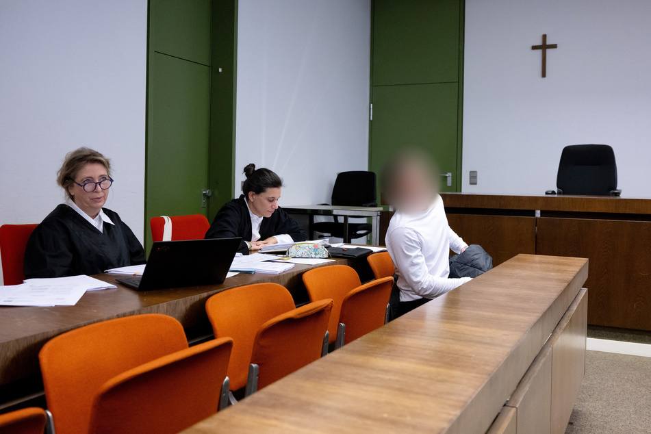 Der wegen Diebstahls angeklagte Mann (r.) sitzt vor Prozessbeginn mit seinen Anwältinnen Ricarda Lang (l.) und Daniela Gabler am Landgericht im Gerichtssaal.