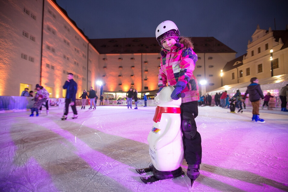 Kleine Eislauf-Helfer unterstützen die Kinder im Schloss beim Schlittschuhlaufen-Lernen.
