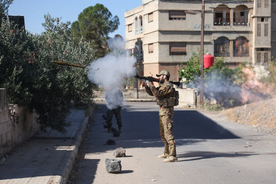 A Syrian security force member fires a shoulder-launched weapon amid clashes in the southern Sweida city on Wednesday.