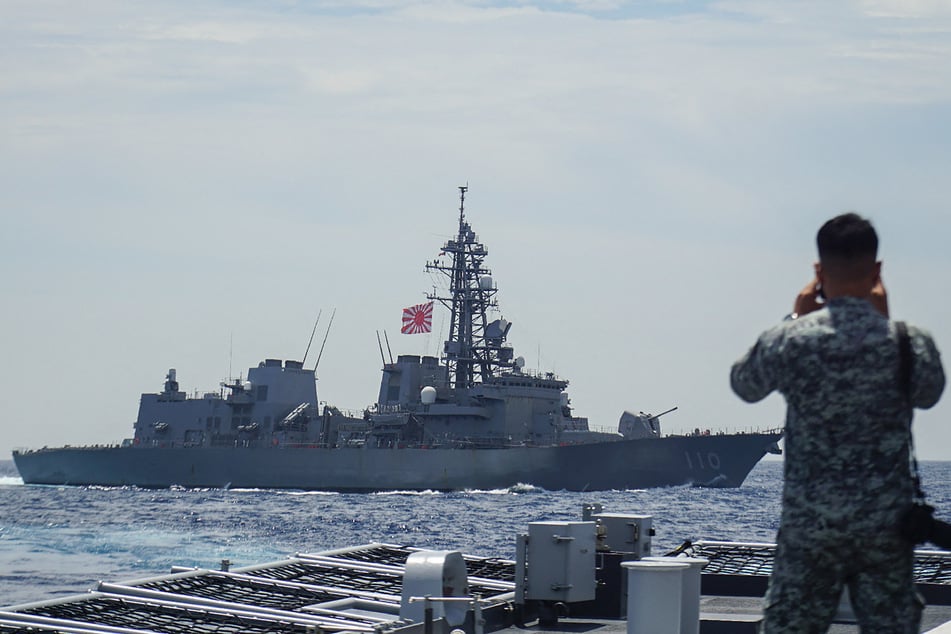 A member of the Philippine Navy looks out at the Japan Maritime Self-Defense Force's destroyer Takanami during a joint maritime exercise in the South China Sea on June 14, 2025.