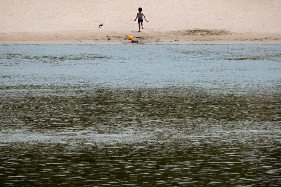 Rumänien, Calarasi: Ein kleines Kind läuft an einem Strand am Ufer der Donau.
