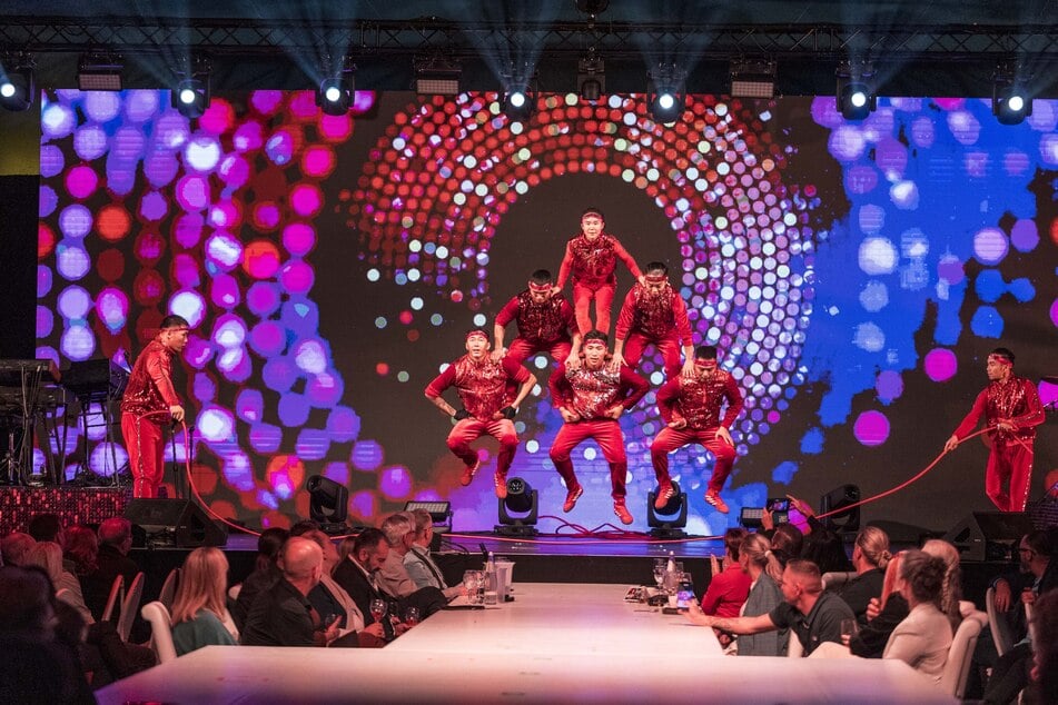 In Pyramidenformation springen die mongolischen Artisten über ein Seil.