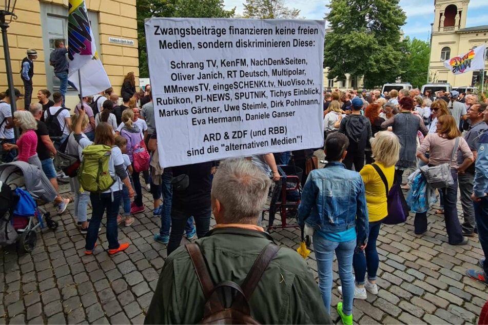 Ein Mann hält ein Schild auf der Demo in Potsdam.
