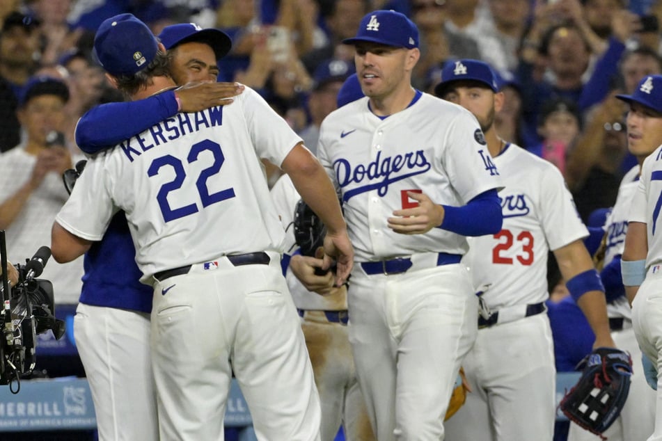 Los Angeles Dodgers starting pitcher Clayton Kershaw is congratulated by right fielder Teoscar Hernandez, first baseman Freddie Freeman, and left fielder Michael Conforto after his 3,000th career strike.
