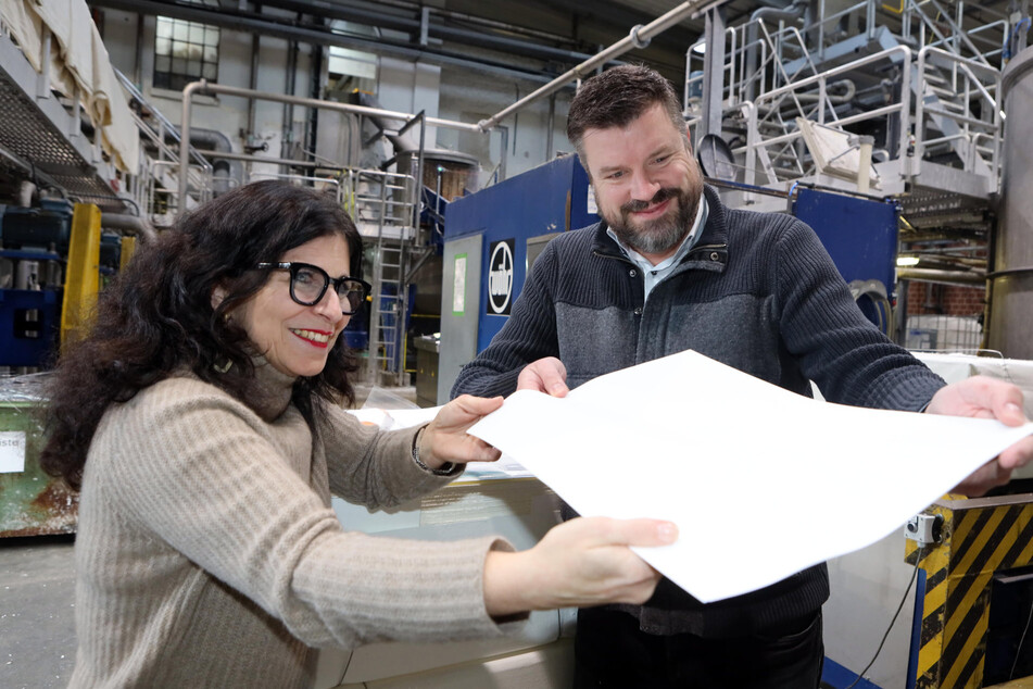 Heidemarie Hinger und Stefan Müller begutachten ein fertiges Blatt Hanfpapier in der Papierfabrik Hahnemühle.