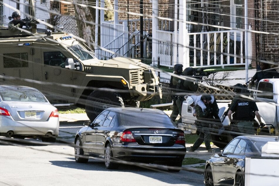 Police evacuate a person from the home in Trenton, New Jersey, on March 16, 2024.