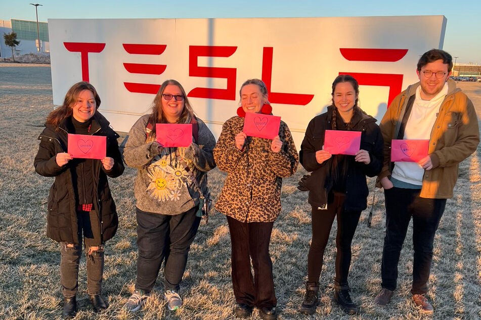 Members of the Tesla Workers United organizing committee pose in front of the company's gigafactory in Buffalo, New York.