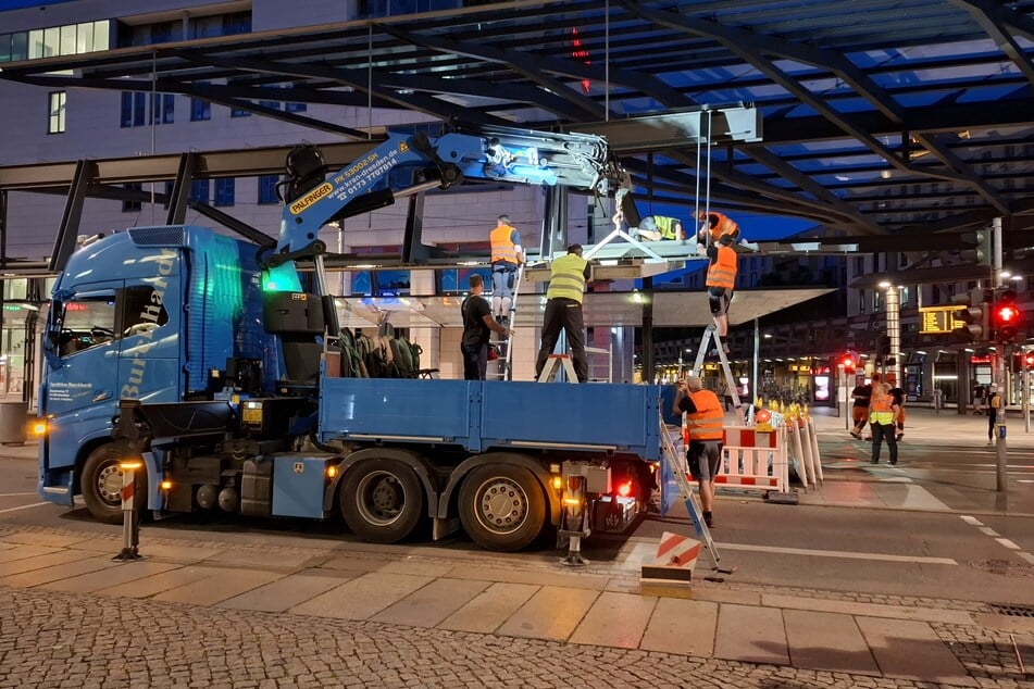 Die defekte Glasscheibe wurde auf eine Hilfskonstruktion gelegt. Arbeiter mussten dafür auf Leitern balancieren und teils sogar auf das Dach klettern.