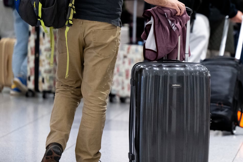 Passagiere stehen am Münchner Flughafen mit ihrem Gepäck an einem Check-In Schalter: Zahlreiche Reisende werden heute von dem Streik der Lufthansa-Flugbegleiter betroffen sein.