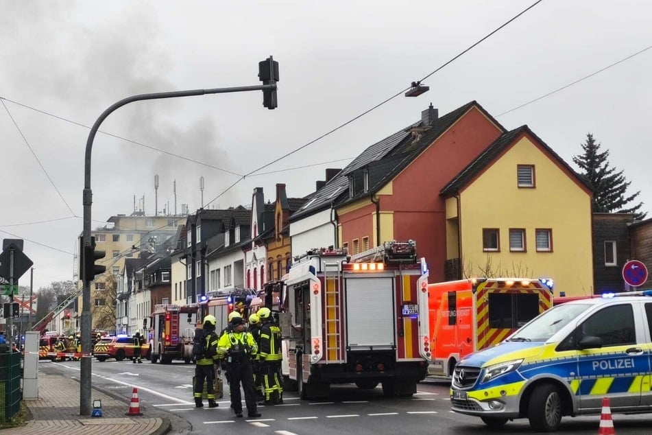 Die Feuerwehr ist mit einem Großaufgebot im Einsatz und kämpft derzeit gegen die Flammen in dem Mehrfamilienhaus in Troisdorf.