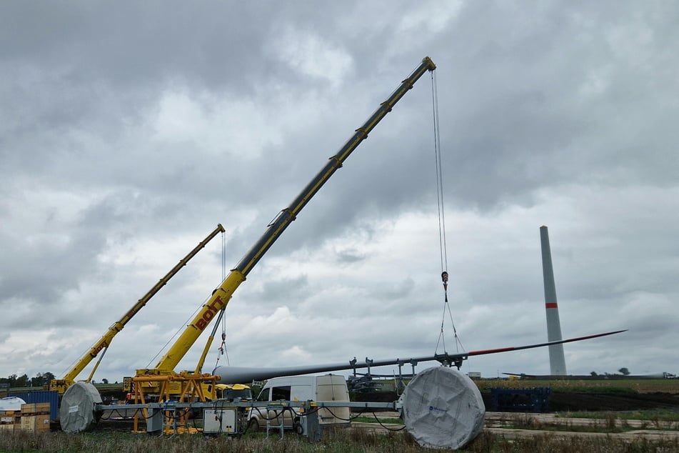 Mit großen Mobilkränen werden die Rotorblätter im Windpark Langendorf von den Schwerlasttransportern gehievt.