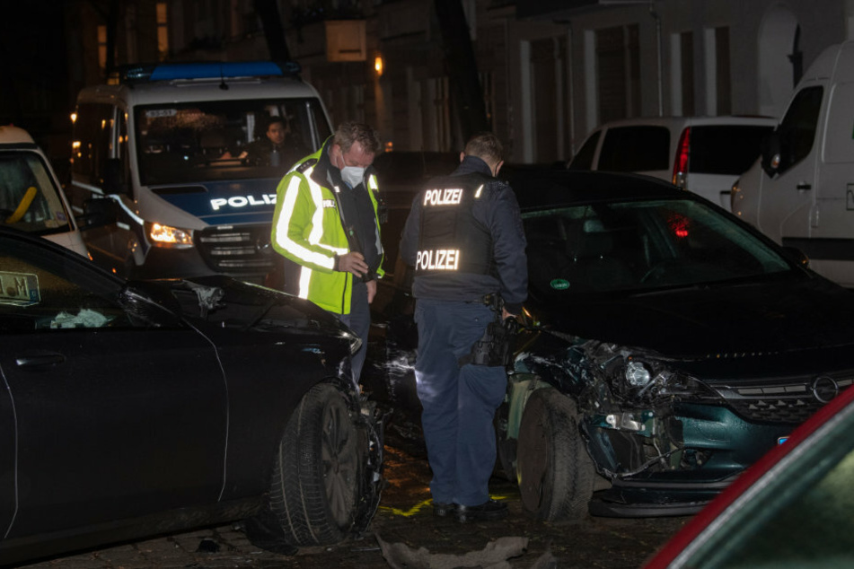 Polizisten betrachten nach der Verfolgungsjagd die beiden Unfallwagen. Bei der Festnahme des 20-jährigen Fahrers soll Polizeigewalt im Spiel gewesen sein.