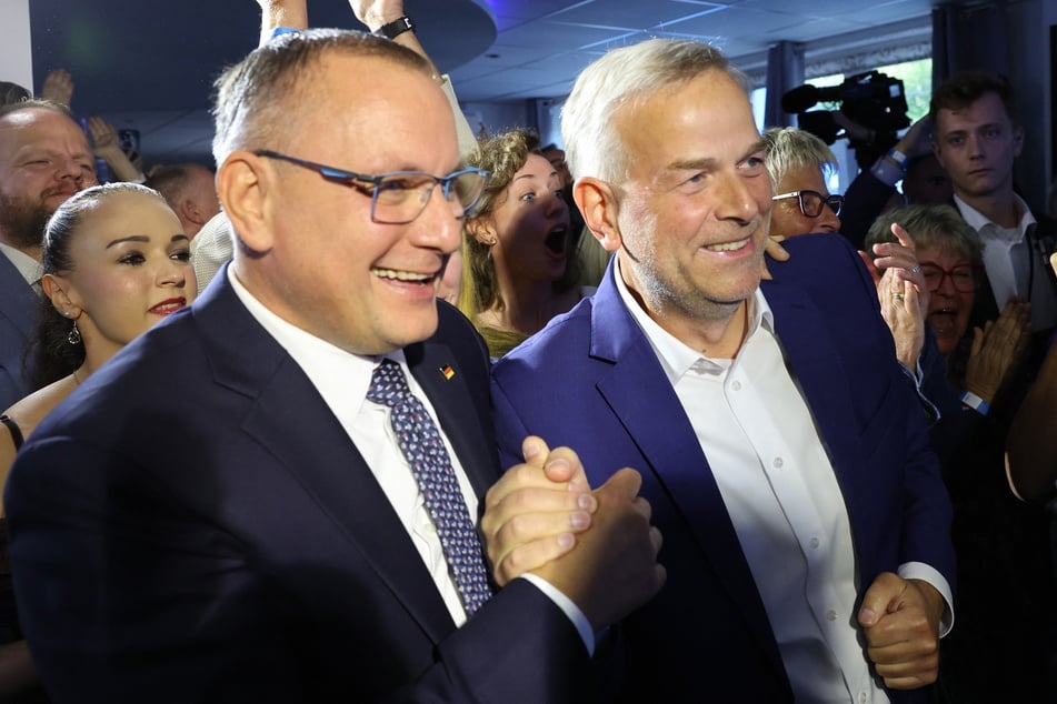 Leif-Erik Holm (AfD, r.), Ministerpräsidentenkandidat der AfD, und Tino Chrupalla (vorne l.), AfD-Bundesvorsitzenderfeiern, feiern auf der Wahlparty ihrer Partei.