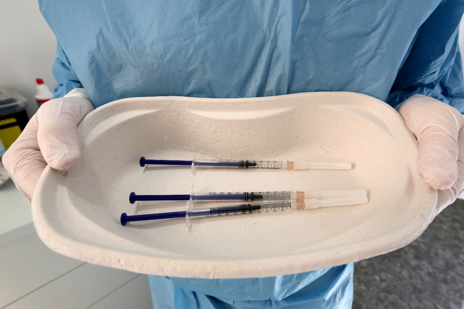 Ein Krankenpfleger zeigt in der mobilen Impfeinheit den in Spritzen aufgezogenen AstraZeneca-Impfstoff.