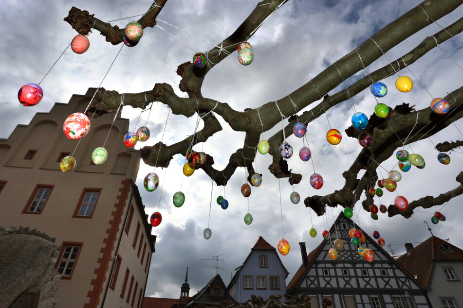 Bayern, Gerolzhofen: Bunte Ostereier schmücken die Bäume auf dem Rathausplatz in der Innenstadt. Zu Ostern steuert Deutschland auf einen beispiellosen Stillstand des öffentlichen Lebens zu.