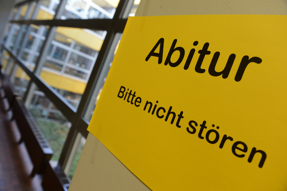 Ein Blatt mit der Aufschrift "Abitur - Bitte nicht stören" hängt an einem Betonpfosten in einem Gymnasium.