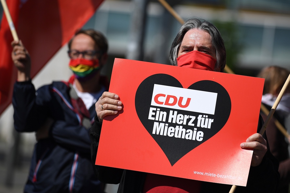 Ein Demonstrant steht mit einem Plakat mit der Aufschrift "CDU ein Herz für Miethaie" vor der CDU-Bundeszentrale, dem Konrad-Adenauer-Haus.
