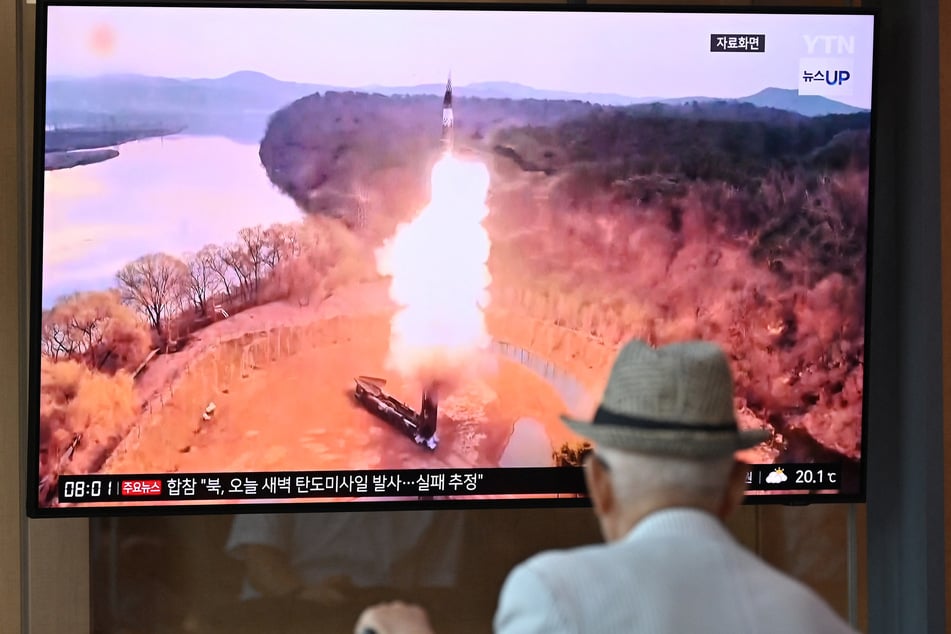 A man watches a television screen showing a news broadcast with file footage of a North Korean missile test, at a train station in Seoul on June 26, 2024. North Korea fired a ballistic missile toward the sea on June 26, the South Korean military said, according to the Yonhap news agency.