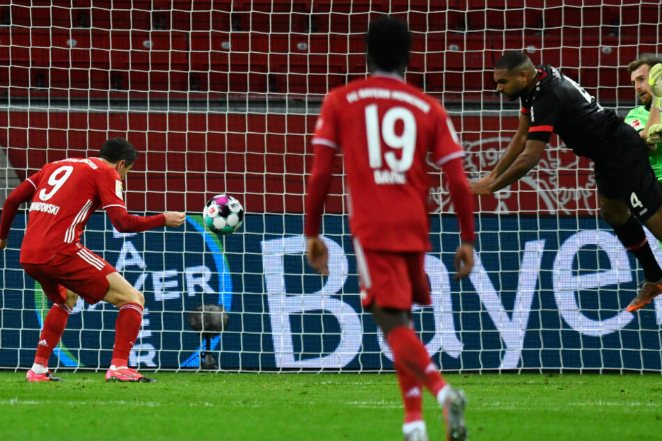 B04-Keeper Lukas Hradecky (r.) und Jonathan Tah (2.v.r.) behindern sich gegenseitig, sodass Bayerns Stürmer Robert Lewandowski (l.) ins leere Tor zum 1:1 einnicken kann.