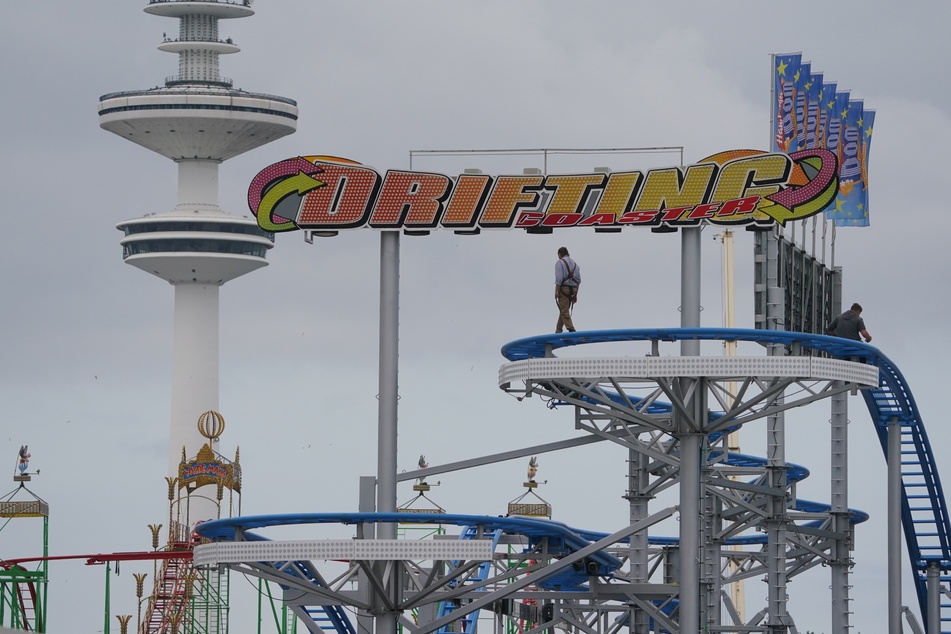 Mitarbeiter bauen das Fahrgeschäft "Drifting Coaster" auf dem Heiligengeistfeld auf. Der Hamburger Sommerdom findet vom 30. Juli bis 28. August 2021 statt.