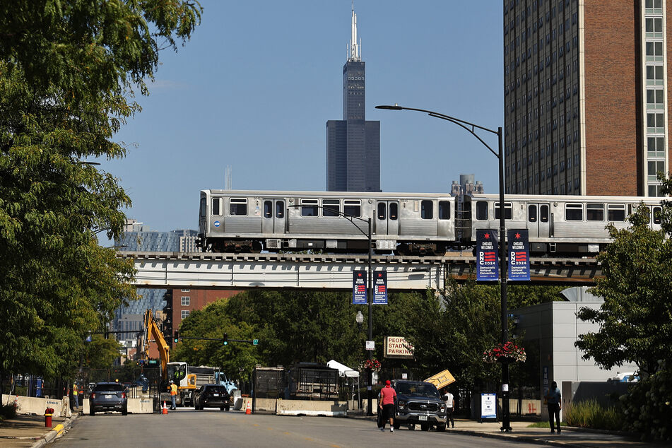 A Chicago Transit Authority Pink Line elevated train rolls over the 10-foot-tall security perimeter fence around the United Center near the site of the 2024 Democratic National Convention, which was held in August.